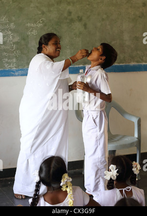 Gouvernement responsable faire pilules anti-worm à l'école les enfants de l'Andhra Pradesh en Inde du Sud Banque D'Images