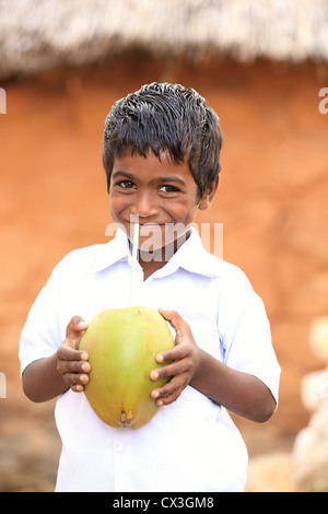 Jeune Indien boy drinking from une noix de coco l'Andhra Pradesh en Inde du Sud Banque D'Images