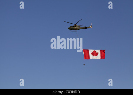 Un hélicoptère porte le drapeau du Canada à l'événement du stampede de Calgary Banque D'Images