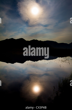 Un lac en Alaska's Brooks reflète parfaitement le ciel et le soleil d'une façon abstraite, Gates of the Arctic National Park, AK, États-Unis Banque D'Images