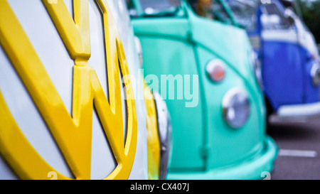 Close up de Volkswagen jaune d'un insigne, avec d'autres campeurs VW colorés en vue au Dunstable doubleurs rencontrez. Banque D'Images