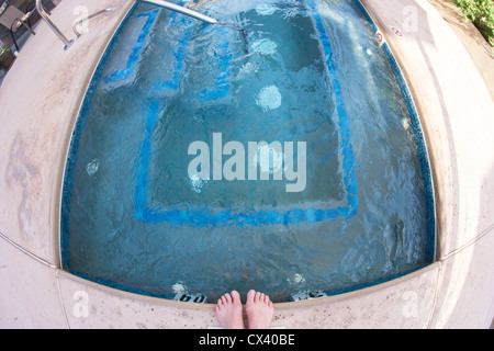Trucs d'une femme des pieds par un bassin d'eau chaude en plein air. Banque D'Images