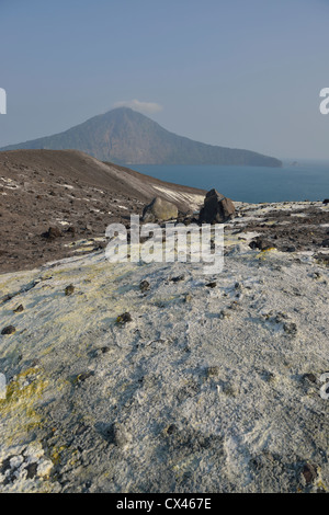 La pente couverte de riches en soufre au débit d'Anak Krakatau avec l'île de Rakata dans l'arrière-plan ; le détroit de la sonde, en Indonésie. Banque D'Images