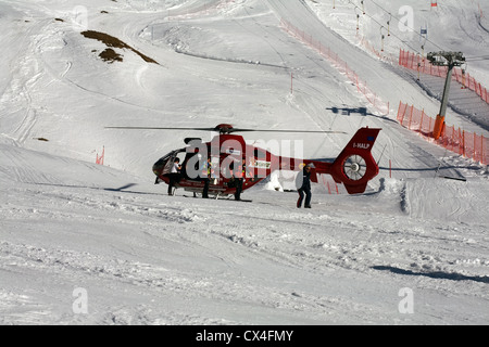 Air Ambulance assister à un grave accident de ski sur une piste à Selva Val Gardena Dolomites en Italie. Type d'hélicoptère EC 135 Banque D'Images