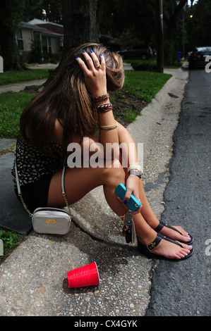 Teenage girl sitting sur le trottoir d'une rue - contrarié déprimé triste underage drinking Banque D'Images