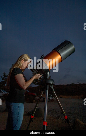 Une jeune femme astronome amateur utilise un catadioptic 2,000mm télescope pour regarder les étoiles sur une soirée à Orange County, CA. Banque D'Images