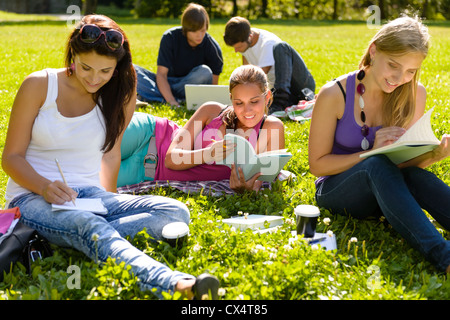 Les adolescents qui étudient au park livre lecture heureux étudiants campus recherche Banque D'Images