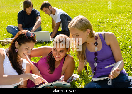 Les adolescents qui étudient au park livre lecture heureux étudiants campus recherche Banque D'Images