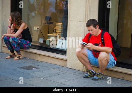 Les gens de la rue de Barcelone. Les jeunes qui étudient la carte touristique était assis sur un rebord de fenêtre boutique sur rue dans Barcelone Catalogne Espagne ES Banque D'Images