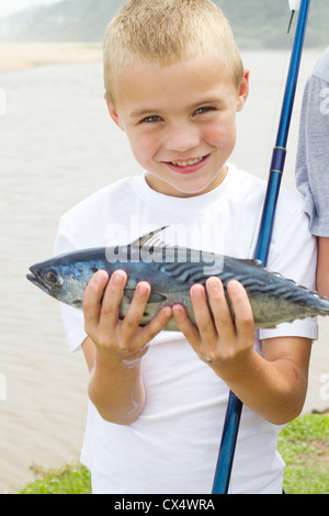 Happy boy un poisson qu'il vient de prendre Banque D'Images