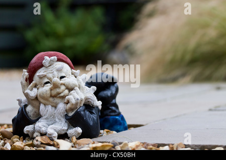 Nain de jardin couché avec ses pieds en pensant Banque D'Images