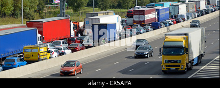 Trafic stationnaire engorgée sur quatre aiguilles lane autoroute M25 avec des aiguilles d'une route permettant de se déplacer librement (certaines plaques obscurci) Banque D'Images