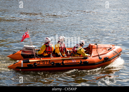 Pêche côtière en bateau de sauvetage de la RNLI Whitby Harbour retour après un cri. Gros plan du bateau avec trois membres d'équipage. Banque D'Images