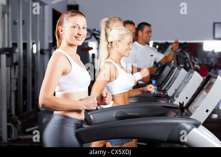 Les gens de remise en forme d'exécution sur tapis roulant dans une salle de sport Banque D'Images