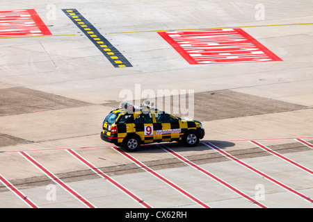 La manutention au sol des avions, maréchal, suivez-moi, voiture à l'Aéroport International de Düsseldorf. L'Allemagne, de l'Europe. Banque D'Images