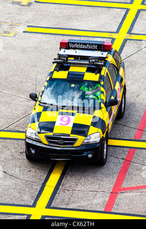 La manutention au sol des avions, maréchal, suivez-moi, voiture à l'Aéroport International de Düsseldorf. L'Allemagne, de l'Europe. Banque D'Images