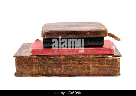 Vieux livres empilés avec des couvertures en cuir sur un fond blanc, transmettant l'histoire et les connaissances. Banque D'Images