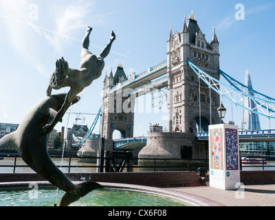 Vue sur le Tower Bridge à partir de St Katherine Docks avec statue de la jeune fille et le dauphin et le fragment dans l'arrière-plan, London, UK Banque D'Images