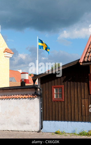 Drapeau suédois sur un mât dans la ville hanséatique de Visby sur l'île de Gotland en Suède Banque D'Images