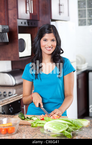 Jeune femme indienne cooking in kitchen Banque D'Images