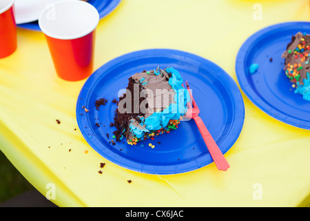 Un morceau de gâteau à moitié mangé sur une plaque à usage unique Banque D'Images