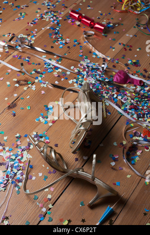 Talons à lanières métalliques, des confettis et des serpentins de détritus d'un plancher de bois franc Banque D'Images