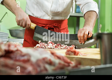 Détail d'une viande à hacher l'homme avec un grand couteau Banque D'Images