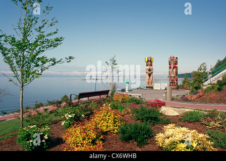 White Rock, BC, en Colombie-Britannique, Canada - Promenade au bord de la passerelle et les Salish de la côte et de mâts totémiques Haïdas le long de la baie Semiahmoo Banque D'Images