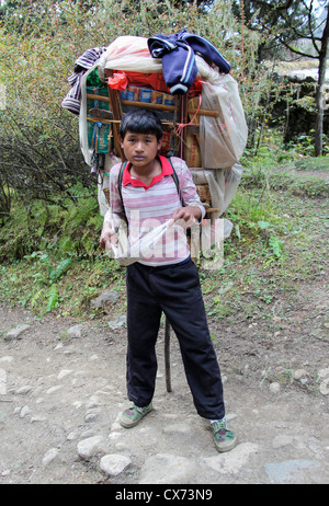 Young boy carrying Sherpa grande charge de produits, Banque D'Images