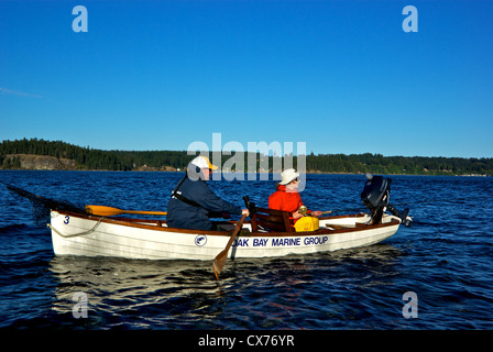 Pêcheur femelle tente de prendre des gros saumons chinook Tyee en piscine de bouche de Campbell River avec aviron barque traditionnelle guide Banque D'Images