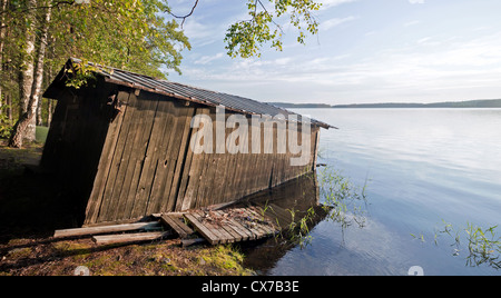 Petit bateau en bois ancien garage sur la côte du lac Saimaa, construction typiquement pour la Finlande Banque D'Images