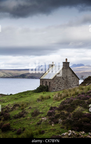 Sous un ciel orageux Crofters cottage avec vue sur le Loch Torridon Wester Ross ouest des Highlands en Écosse Banque D'Images