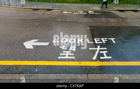 Look 'gauche' signe sur une rue de hong kong, de conseiller la sécurité des piétons Banque D'Images