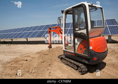 Mechanical digger sur panneau solaire construction site Banque D'Images