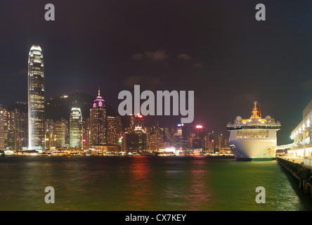 Skyline de Hong Kong à la soirée avec un bateau de croisière sur la droite en face de l'ocean terminal Banque D'Images