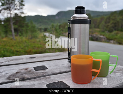 Thermos et deux tasses en plastique sur la table Banque D'Images