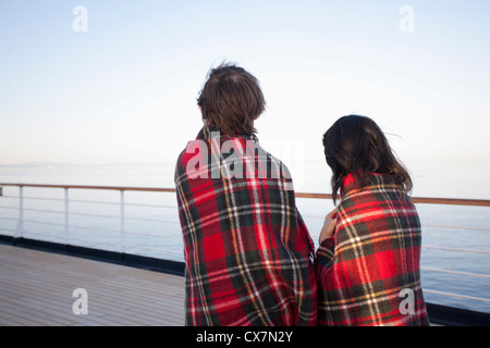 Un couple sur un pont de navire, enveloppés dans des couvertures, à la vue, à Seattle, Washington, USA Banque D'Images