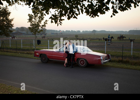 Un couple de rockabilly appuyé contre une voiture d'époque dans le pays Banque D'Images