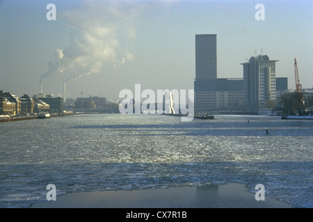 Vue sur la Spree avec cheminée industrielle la fumée et statue de 'Molecule Man' en arrière-plan Banque D'Images