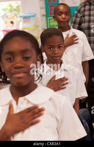 Les enfants de l'école des Bahamas allégeance au drapeau à New Plymouth sur Green Turtle Cay, Bahamas. Banque D'Images