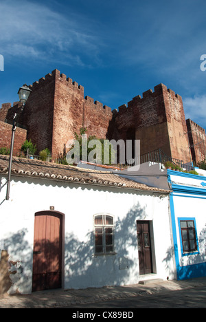 ALGARVE, PORTUGAL. Les petits cottages blanchis à la chaux typiques de Silves, avec le Château des Maures derrière. 2012. Banque D'Images