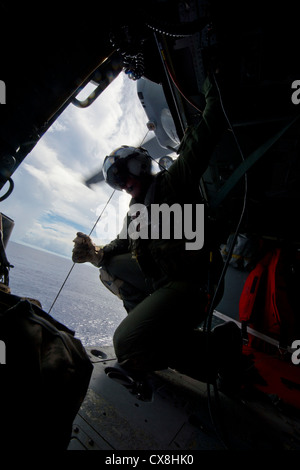 Mer des Philippines (sept. 17, 2012) aircrewman de marine 2e classe William branson abaisse un panier au cours d'un exercice de recherche et sauvetage d'un MH-60s Sea Hawk, affecté à l'escadron d'hélicoptères de combat de la mer (HSC) 25. hsc 25 est actuellement en cours avec l'avant-déployé d'assaut amphibie USS Bonhomme Richard (DG 6), le navire de tête de la seule l'avant-déployée groupe amphibie. Banque D'Images