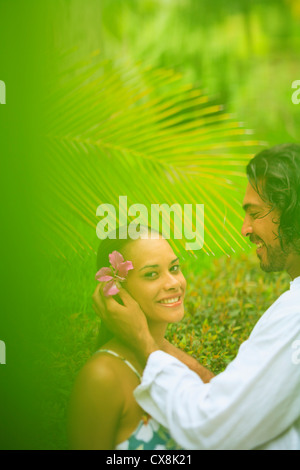 Un homme met une fleur dans les cheveux d'une femme au bora bora nui resort and spa;l'île de Bora Bora, le pacifique sud Banque D'Images