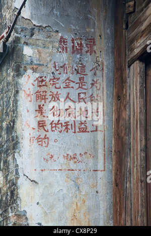 Les mots du président Mao écrit sur les murs dans une ville ancienne près de Guilin dans la région autonome Zhuang du Guangxi Banque D'Images
