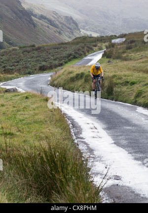 Cycliste sur des lacets sur Hardknott pass in Lake District Banque D'Images