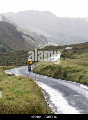 Cycliste sur des lacets sur Hardknott pass in Lake District Banque D'Images