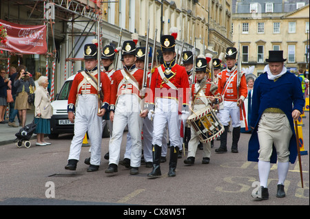 Manteau rouge des soldats en costume uniforme Regency mars à centre-ville de Bath au début de la Jane Austen Festival Banque D'Images