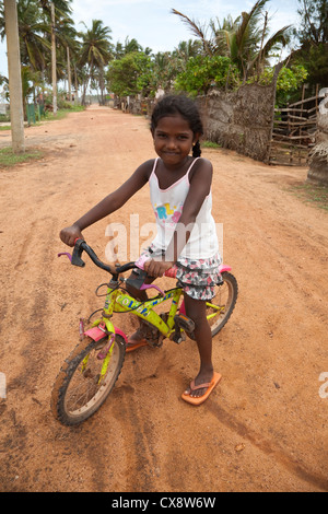 Petite fille sur son vélo pédale, Waikkal Village, Sri Lanka Banque D'Images