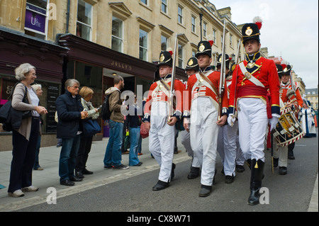 Manteau rouge des soldats en costume uniforme Regency mars à centre-ville de Bath au début de la Jane Austen Festival Banque D'Images