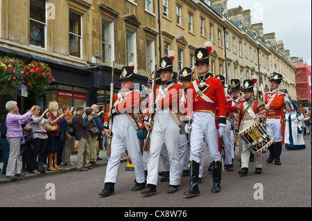 Manteau rouge des soldats en costume uniforme Regency mars à centre-ville de Bath au début de la Jane Austen Festival Banque D'Images